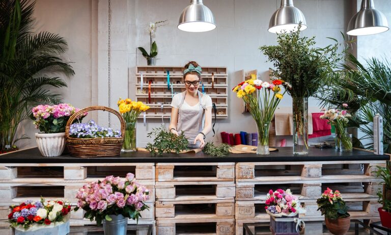 En florist som gör en blombukett i en blomsteraffär